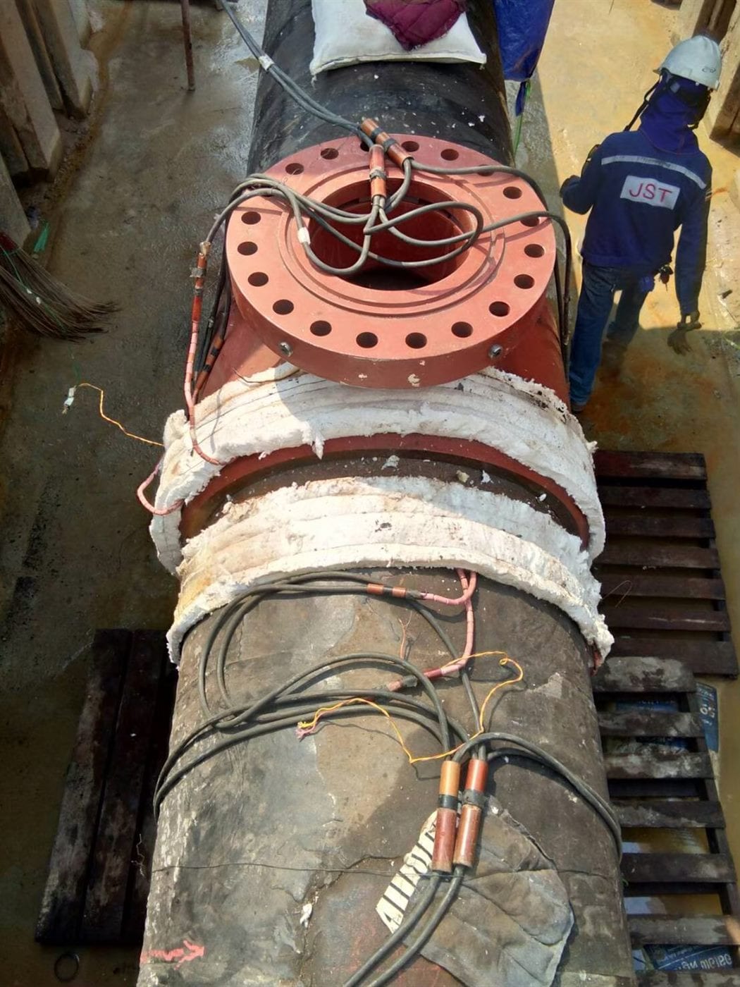 Flange and pipe weld wrapped with PWHT heating cables and insulation