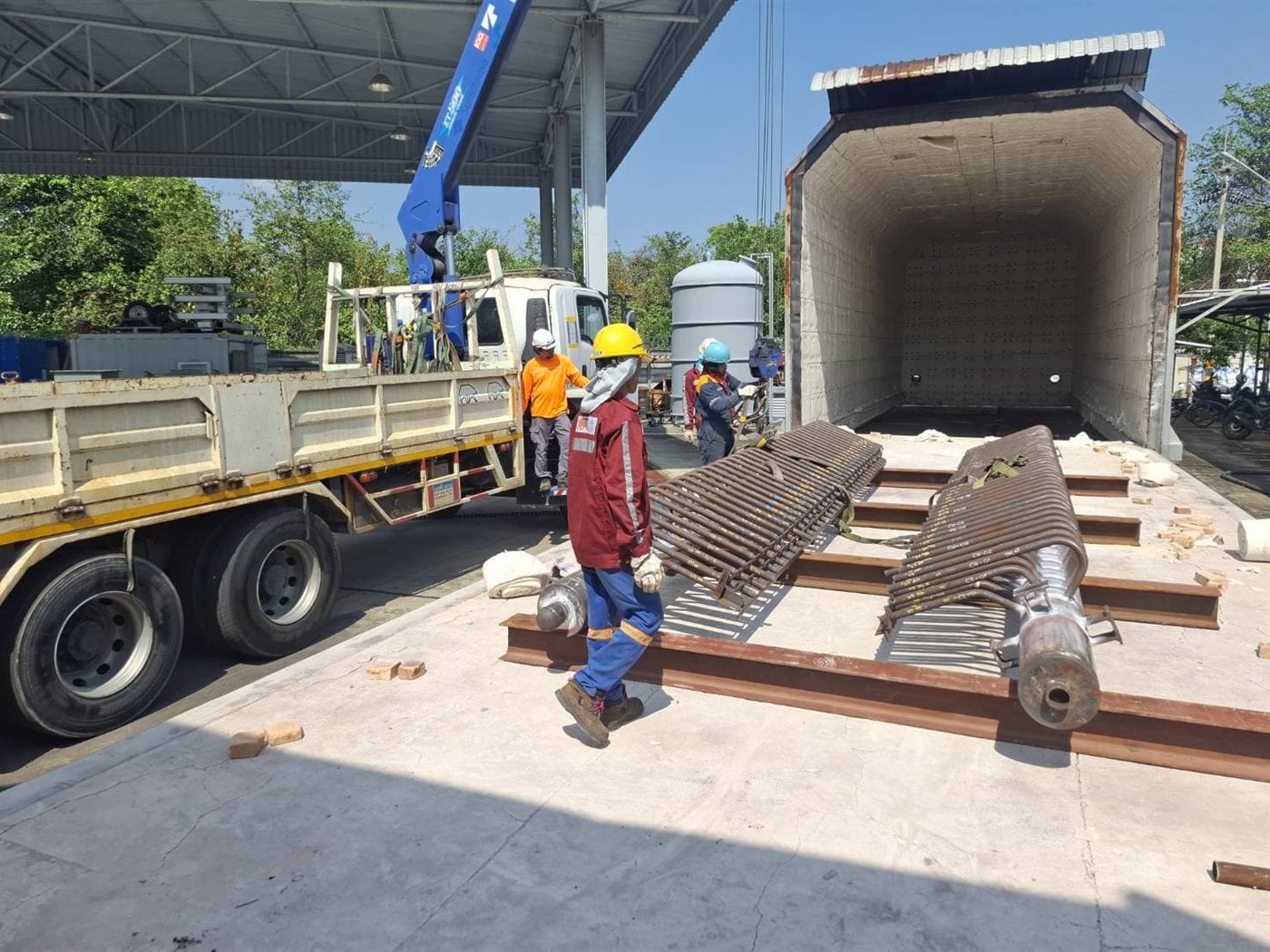 Technicians loading fabricated components into a heat treatment furnace