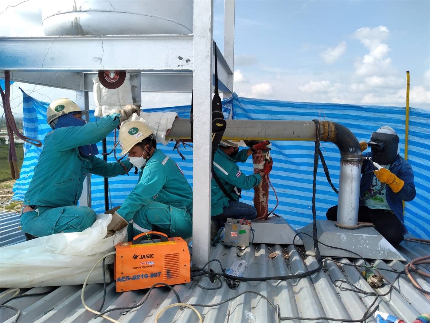 JST technicians installing heat treatment equipment on rooftop piping
